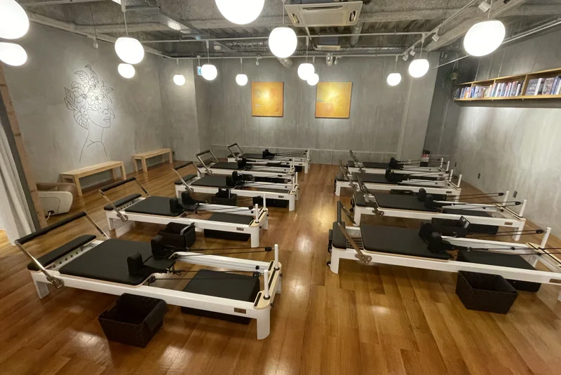 TSUTAYA Conditioning PILATES 牧野駅前店のアートワークと本棚を望むスタジオ
