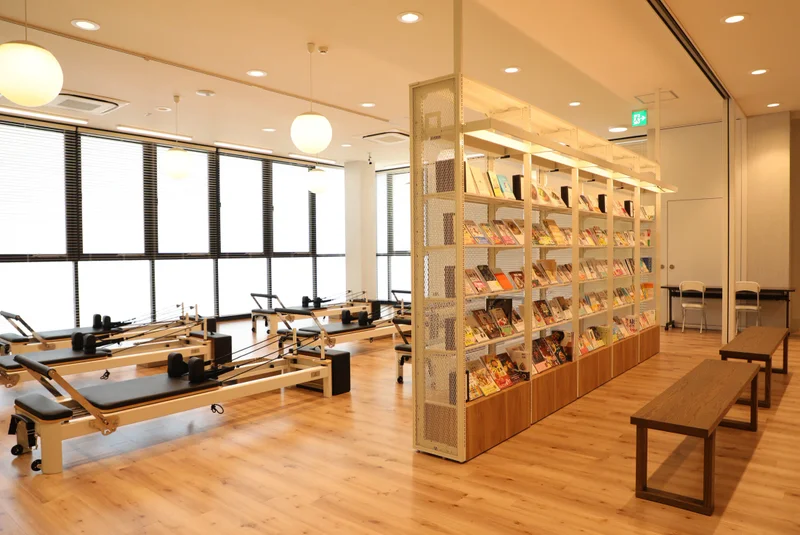 TSUTAYA Conditioning PILATES 宇都宮駅東口店のピラティススタジオとブックシェルフ