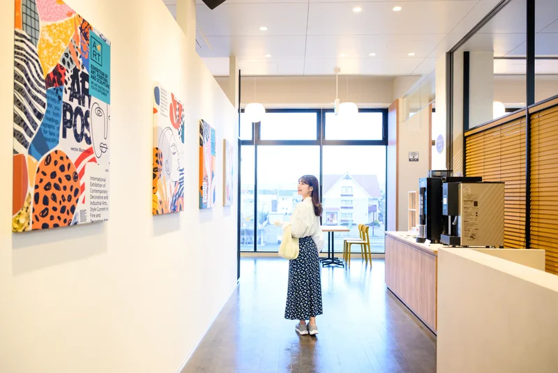 TSUTAYA Conditioning 福井高柳店のアートが並ぶ館内エントランスを歩く様子