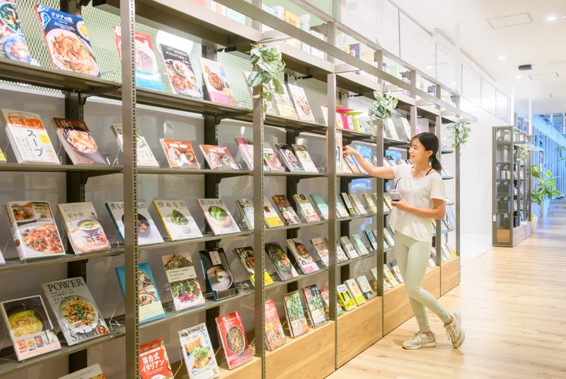 TSUTAYA Conditioning スポーピアシラトリ静岡店のブックラウンジで本を選ぶ様子