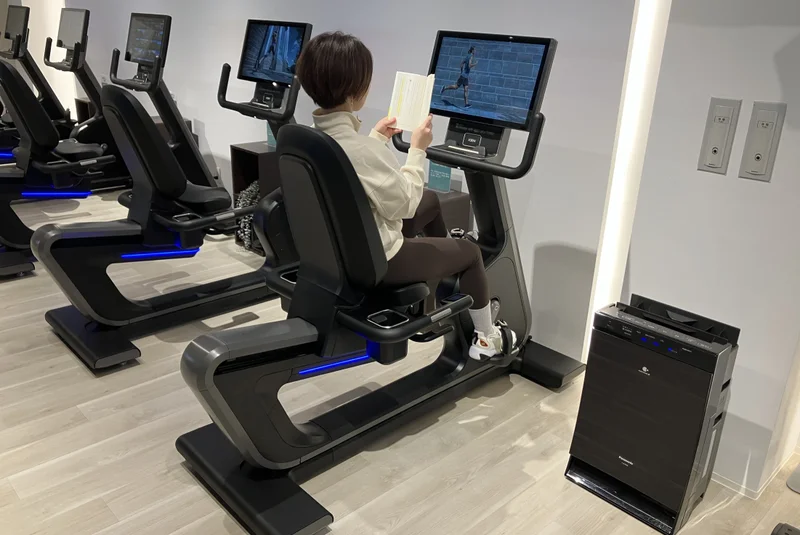 TSUTAYA Conditioning 香里園店でバイクトレーニングをしながら本を読む様子